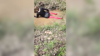 Outdoors in woods and stream crossdressed playing.