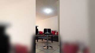 Sissy ladyboy using a large sex-toy on a chair wearing heels