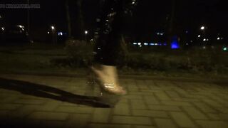 crossdresser walks on the street in transparent high heels