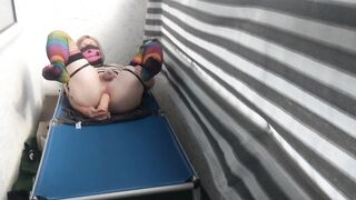 Caged sissy plays with her vibrator on public balcony
