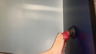 Lubing up and rubbing a sex tool with her feet