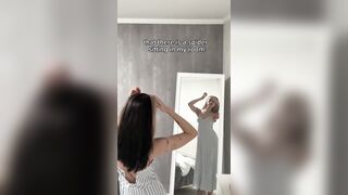 Striped suit rides up as this babe flexes her arm in the mirror