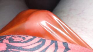 Masturbating in a red plastic strap
